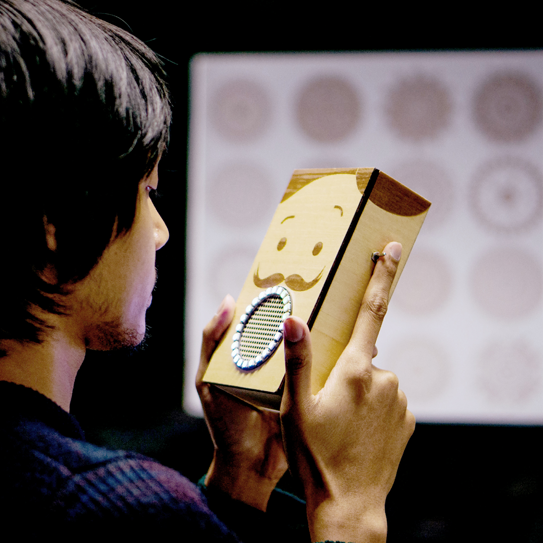 A person interacting with a cardboard talking device