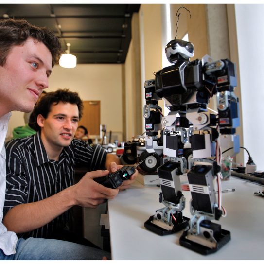 Two students using a robot they've developed